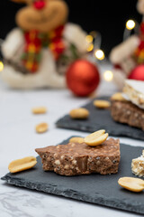 Traditional Spanish sweet - turrón, on a table with lights and Christmas decorations