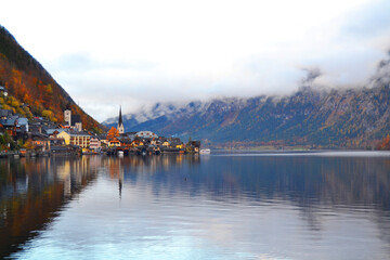 Obraz premium Hallstatt town view in a foggy day and clouds between the mountains. Amazing autumn cityscape, Austria, Salzkammergut