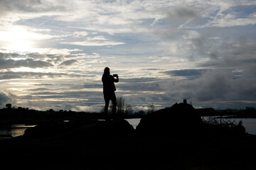 Woman taking photos in Los Barruecos, granite formations and ponds with great animal diversity in a natural monument in Extremadura