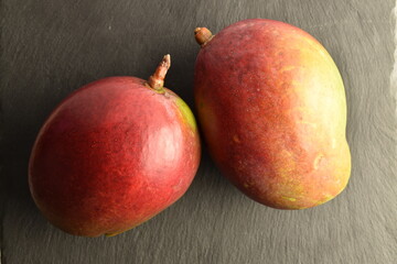 juicy mangoes close-up, on a slate board.