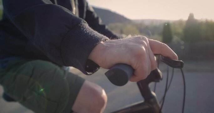 Close up, elderly man hand while on bike