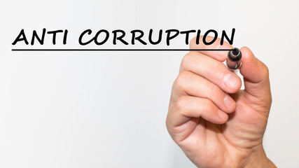 the hand writes text ANTI CORRUPTION with a marker on a white background. business concept