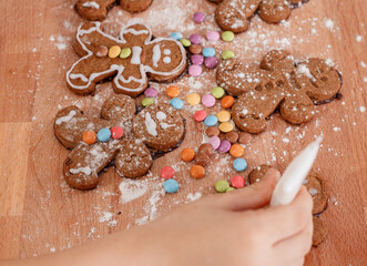 Making gingerbread cookies for Christmas. Making ginger cookie on Christmas decorated table on festive lighting background.