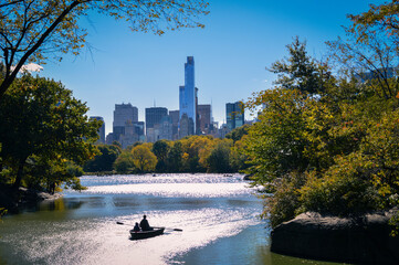 People rowing in boat in central park
