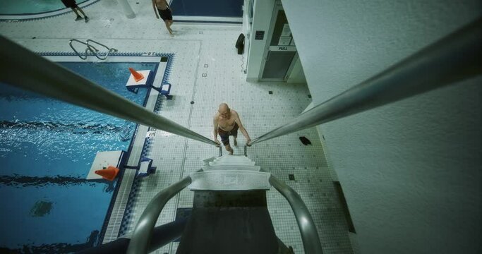 High Angle, Man Climbs Diving Board Ladder At Local Swimming Pool