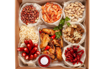 Food delivery box for Dinner. Food delivery from markets and restaurants. Meal for a week on quarantine Chicken wings, shrimp nuts crackers sausages to beer at the craft box. Contactless delivery