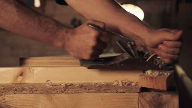 Carpenter working with jointer on wooden block