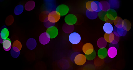 Abstract defocused bokeh background on black background.