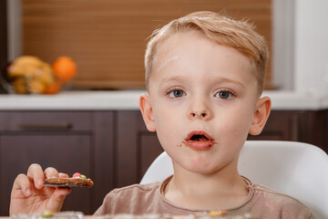 Boy holding a tray full of homemade gingerbread cookies. Kids bake Christmas cookies. Horizontal...