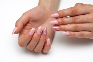 Nude, nude, beige, light pink manicure with white stains, smoke on the nails, on long oval nails close-up on a white background.