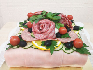 Meat and sausage cake garnished with cherry, olives, lemon and parsley. Unusual holiday gift