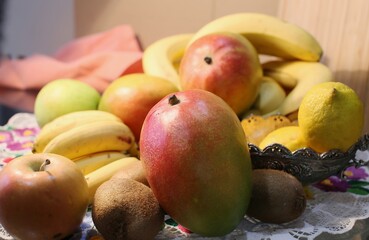 Fresh exotic fruit: mango, lemon, bananas, kiwi on a napkin on a table