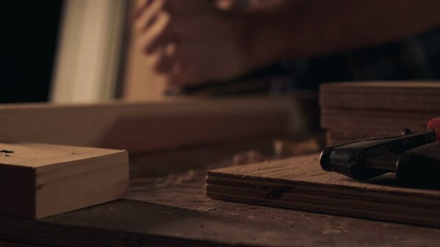 Carpenter working with jointer on wooden block