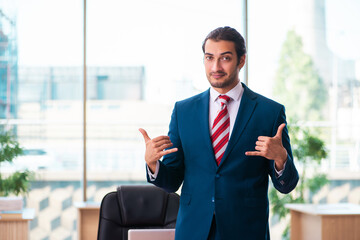 Young handsome employee working in the office