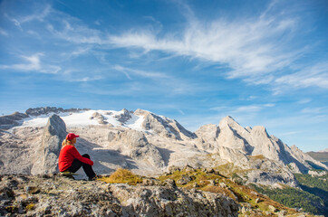 Fototapeta na wymiar Sporty young woman relaxing on mountain trail Marmolada, Dolomites Mountains, Italy. Sport, success, inspiration