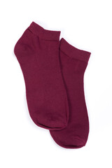 Pair of burgundy short socks on white background, top view