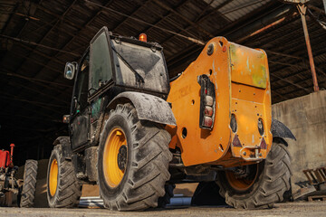 Low angle view of tractor in a barn. Ordinary day on farm.