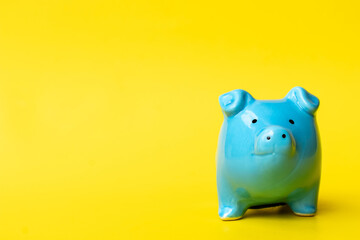 Blue piggy bank smile isolated on yellow background. Finance, saving money concept.