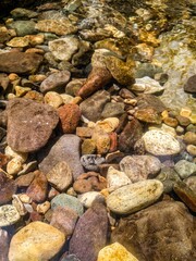 River stones in clean water on sunny day
