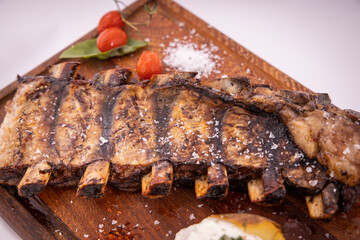 Delicious juicy grilled pork ribs meat on wooden cutting board