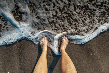Selfie of man bare feet on sand beach and wave, summer concept. - Powered by Adobe