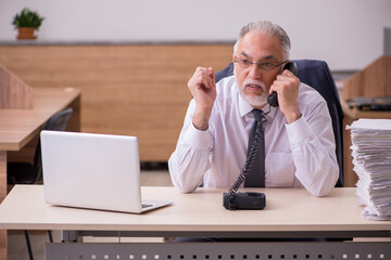 Old male employee unhappy with excessive work in the office