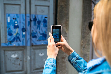 Woman taking picture of a street artworks by phone