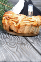 Baked cinnabons in shape. Stand on black pine planks. Nearby are spruce branches, medical masks and an antiseptic.