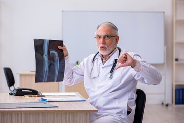 Old male doctor radiologist working in the clinic