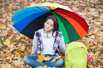 No more rain. girl with backpack under rain protection. child relax in autumn forest. fall leaves...