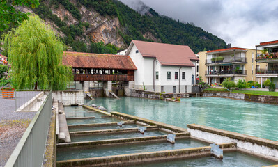 Fototapeta na wymiar Interlaken. Old wooden dam on the mountain river Aare.