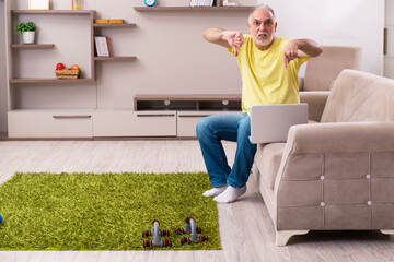Aged man doing sport exercises at home