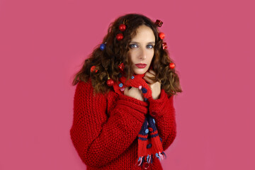 Beautiful girl with christmas toys in hair on red background