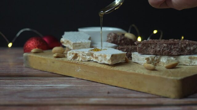 Traditional Spanish sweet - nougat with honey on a table with lights and Christmas decorations