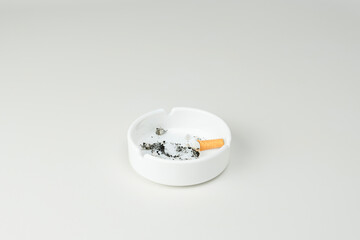 A dirty ashtray with cigarette ashes and butt on white background. Copy space
