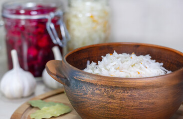 Homemade Sauerkraut with Carrot and Salad Cabbage with Beetroot on a wooden table. Fermented food.