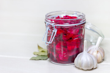 Fermented red cabbage lies in a glass jar. Sauerkraut with spices. Horizontal orientation with copy space.