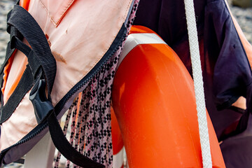 Lifebuoy and life jacket orange and white, rope with floats (buoys). Post with attributes of first...