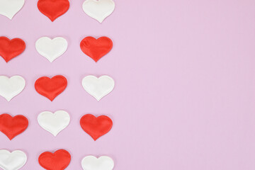 Red and white hearts on a pink background, arranged in three rows on the left side of the image