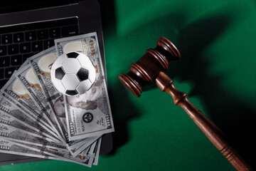 Soccer ball and wooden gavel. Corruption in sports or betting concept.