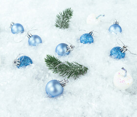 Fototapeta na wymiar Christmas blue balls with fir branches on the snow on a white background.