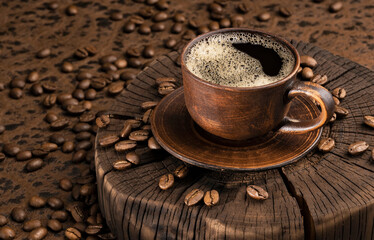 coffee in a clay cup and plate, whole or ground coffee beans lie on a brown wooden table