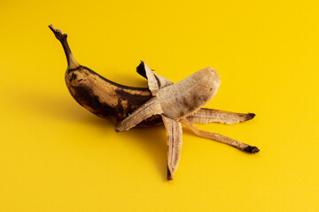 Rotten banana on yellow background.