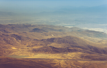 Amazing aerial view of desert, stone hills, and distant mountains layers range.Wilderness background. Vintage toning effect. Near Mount Erciyes. Kayseri, Turkey.