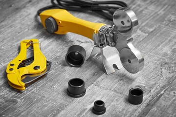 Fototapeta premium A soldering iron or welding machine for plastic polypropylene pipes with attachments and scissors is ready for soldering pipes for water or heating systems.