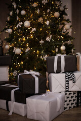 New Year's gifts are under the tree. Large white gift boxes. Beautiful Christmas tree in toys.
