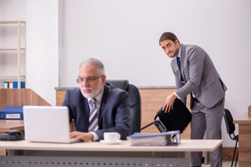 Old boss and young male assistant in the office