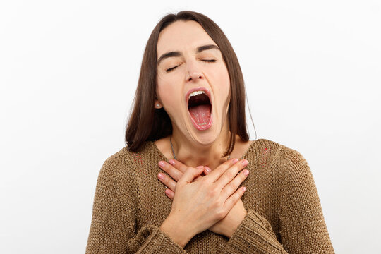 Beautiful woman yawns of boredom on white background