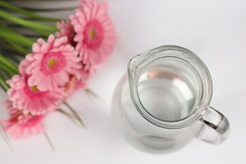 Vase and flowers (gerbera) on background
