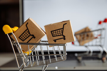 Boxes in a trollies on a laptop keyboard close-up. Online shopping concept.